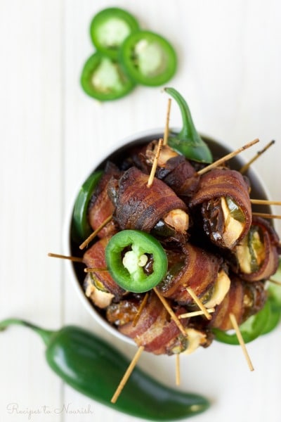 Bowl of bacon wrapped dates stuffed with cream cheese and jalapeño slices.