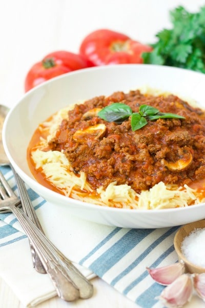 Bowl of spaghetti with bolognese sauce and fresh tomatoes and herbs. 