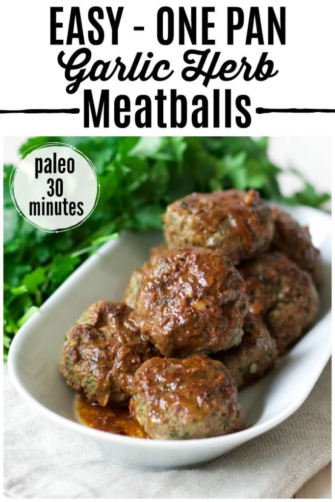 Plate full of meatballs surrounded by fresh herbs.