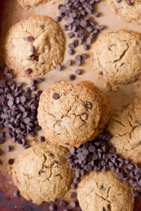 Stacks of chocolate chip cookies surrounded by chocolate chips.