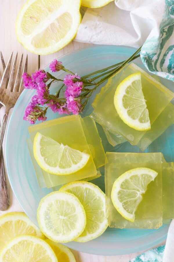 Square slices of homemade lemon jello with lemon slices.