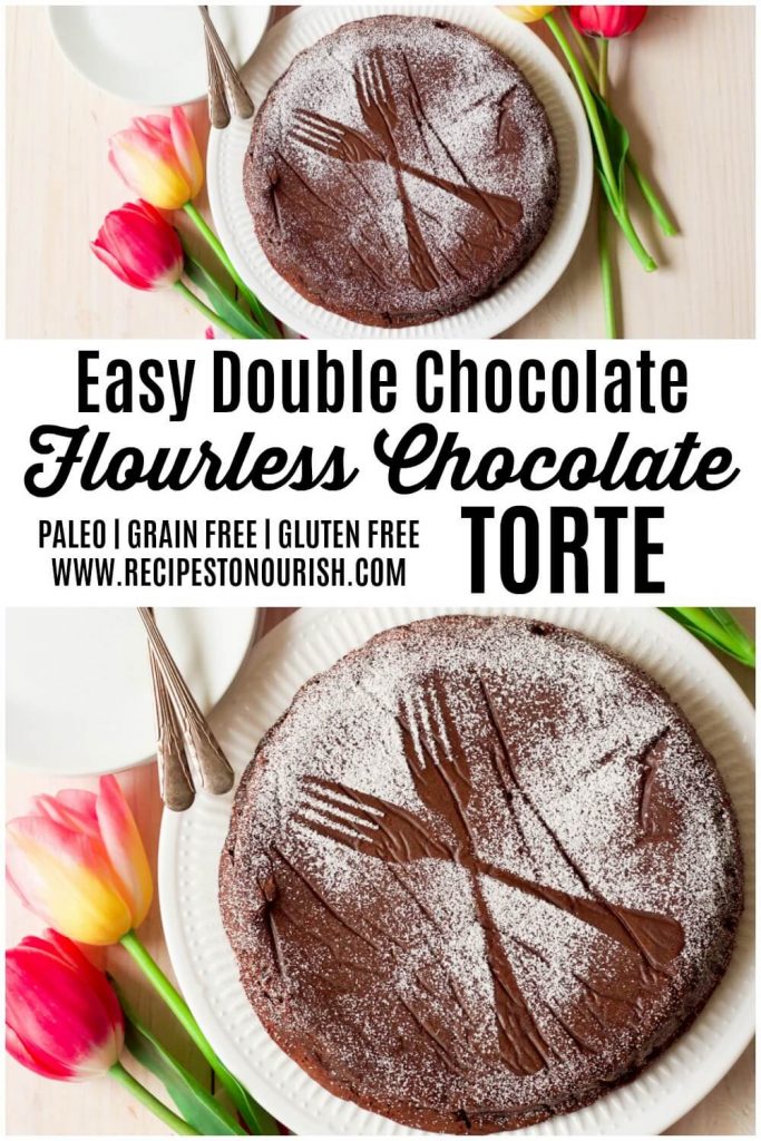 Chocolate torte cake dusted with powdered sugar making two forks sample next to tulips.